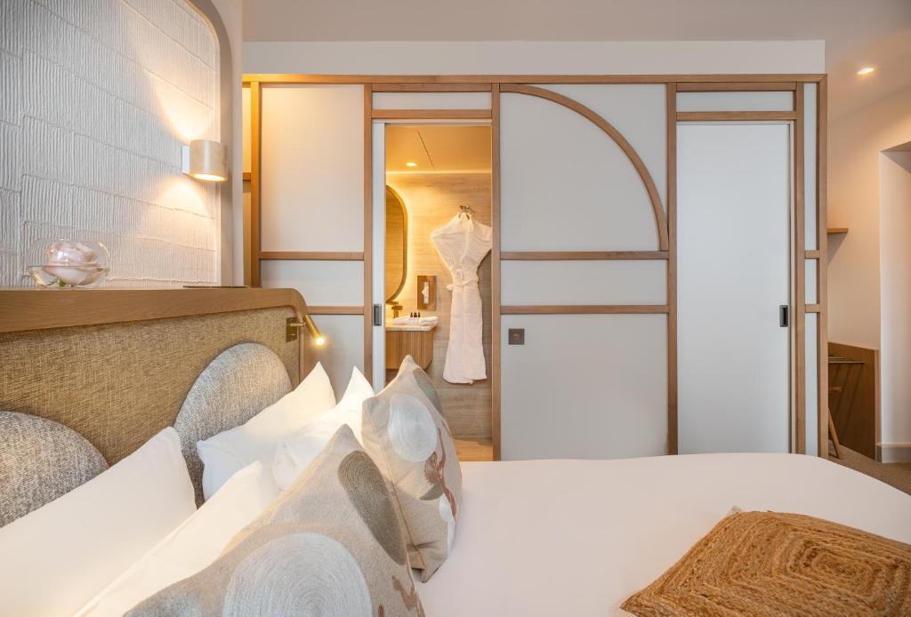 - une chambre avec un grand lit blanc et un miroir dans l'établissement Hôtel Le Monna Lisa by Inwood Hotels, à Paris