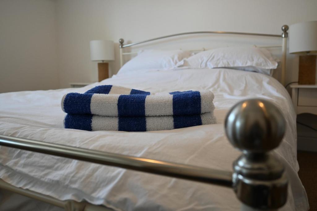 Una cama con toallas azules y blancas. en Apartment No. 8, 1 bed, sleeps 4 en Exmouth