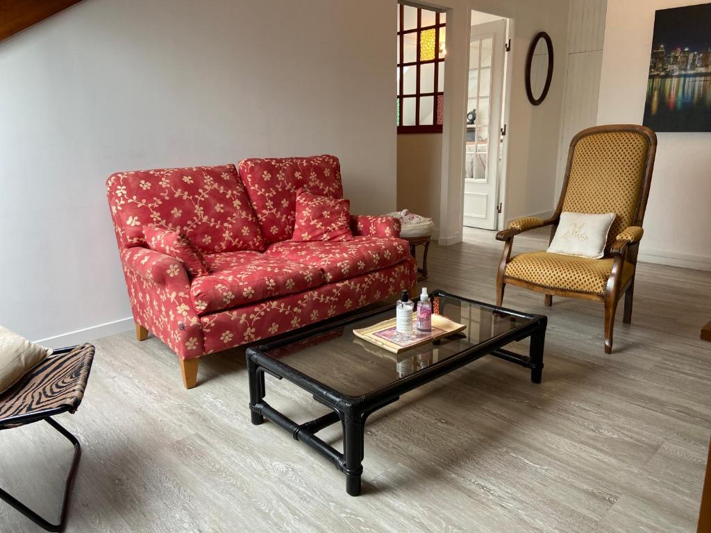 salon z czerwoną kanapą i stolikiem kawowym w obiekcie Appartement entier en résidence centre ville w mieście Vendôme