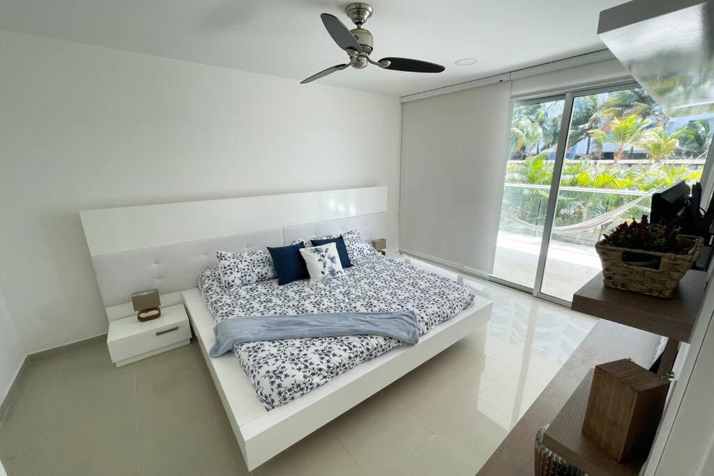 a white bedroom with a bed and a window at LUJOSO Apartamento en Cartagena Incluye Servicio Domestico in Cartagena de Indias