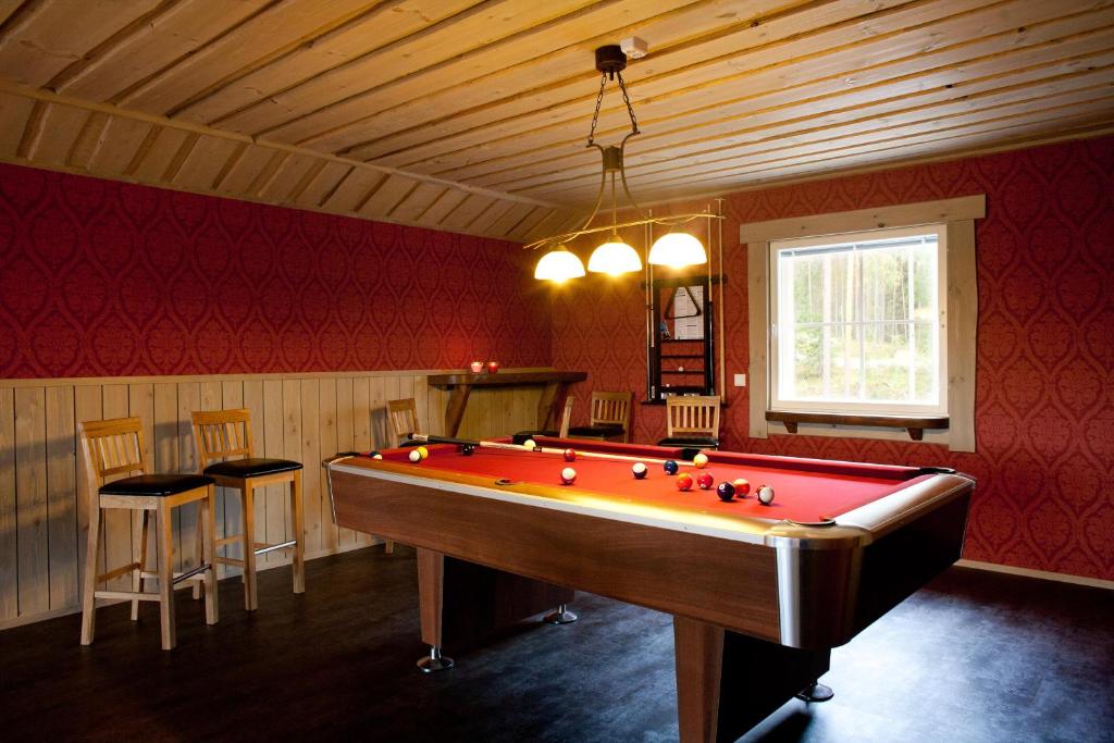 Zimmer mit einem Billardtisch mit Stühlen und einem Fenster in der Unterkunft Villa Valmuska in Mikkeli