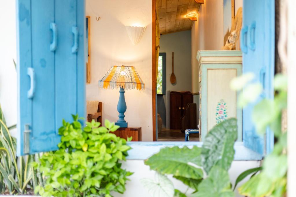 een blauwe lamp in een kamer met blauwe deuren bij Casa PROX AO MAR - Icaraizinho de Amontada in Amontada