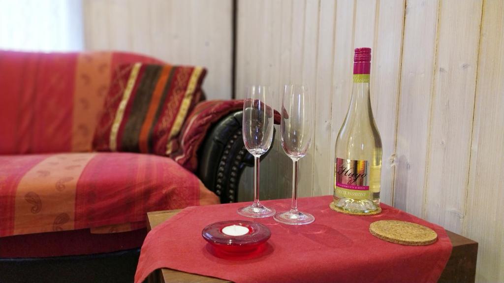una botella de vino y dos copas de vino en una mesa en Inselromantik Rügen, en Dreschvitz