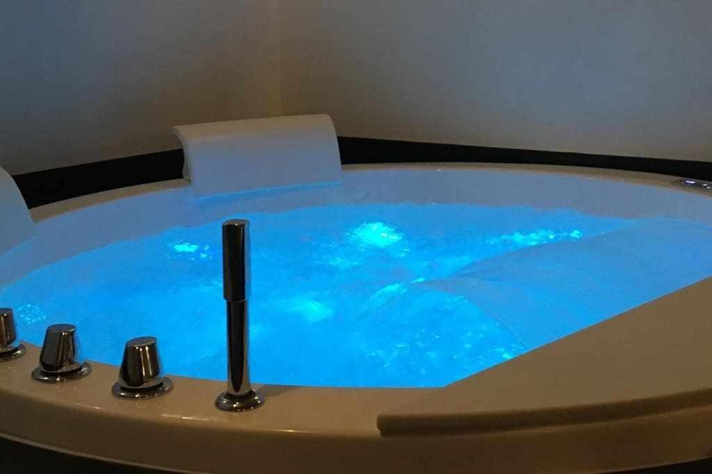 - une baignoire avec de l'eau bleue dans la chambre dans l'établissement Lo Bòi Avise, à Avise