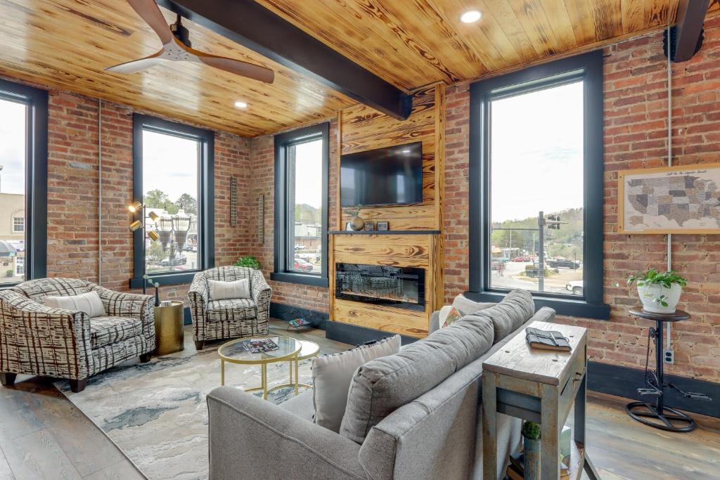 a living room with a brick wall at Luxurious Downtown Murphy Vacation Rental Loft! in Murphy