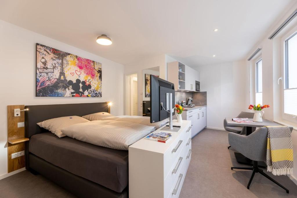 1 dormitorio con 1 cama y escritorio con ordenador en Haus Andersen Apartment EINS, en Norderney