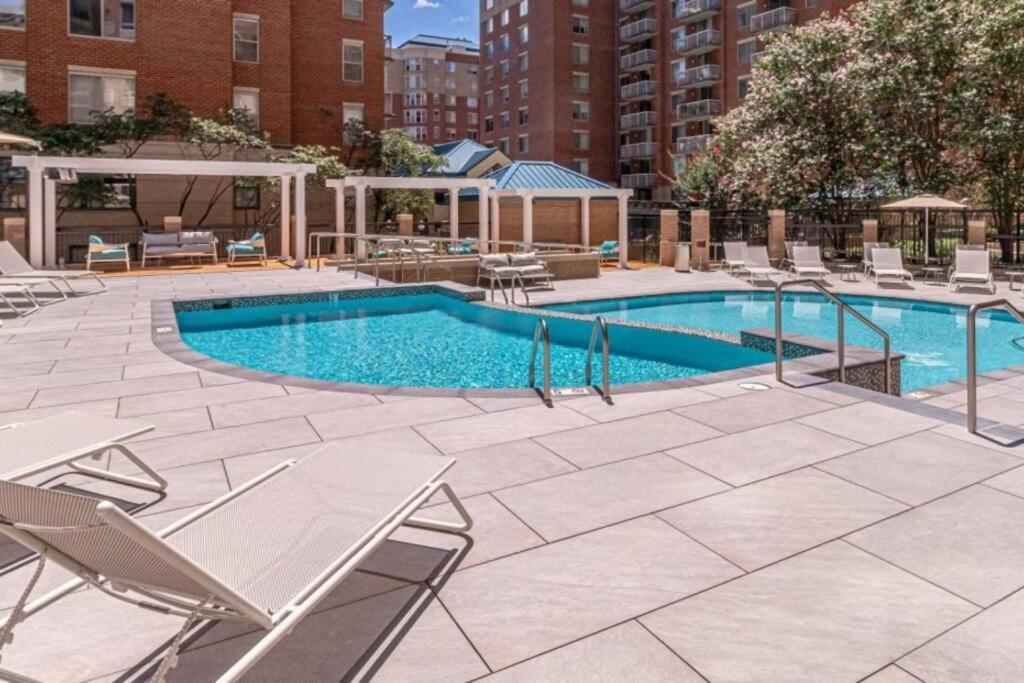 a swimming pool with lounge chairs and a swimming pool at Fantastic 1 Bedroom Condo At Ballston With Gym in Arlington