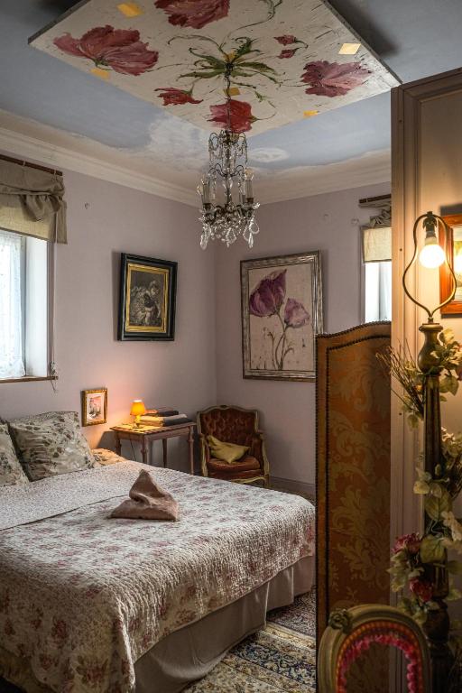 une chambre avec un lit et un lustre dans l'établissement Chambres d'hôtes Villa l'espérance, à Étretat