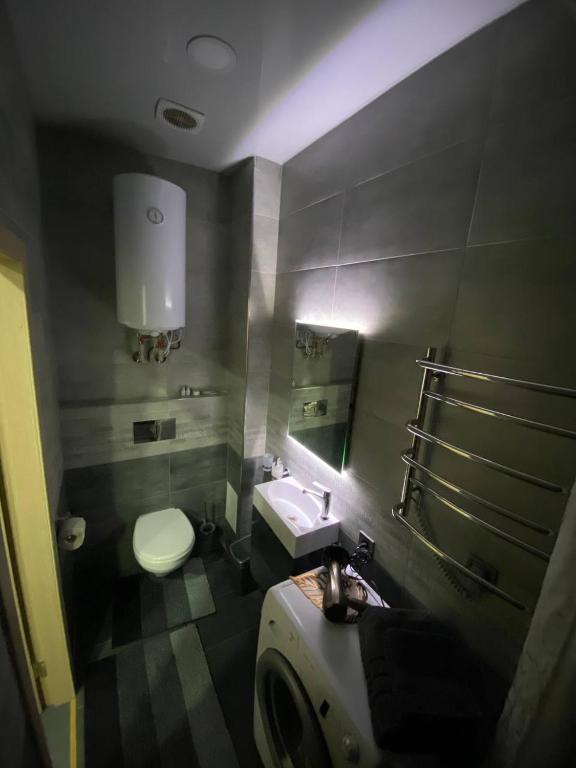 a bathroom with a toilet and a sink and a mirror at Luxury Room_Karavaeva in Dnipro