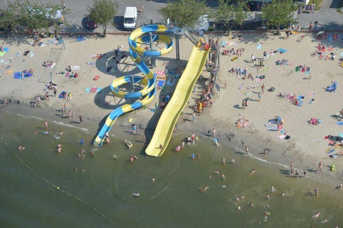 grupa ludzi na plaży ze zjeżdżalnią wodną w obiekcie Entre Terre et Mer, Bruges, Ostende w mieście Jabbeke