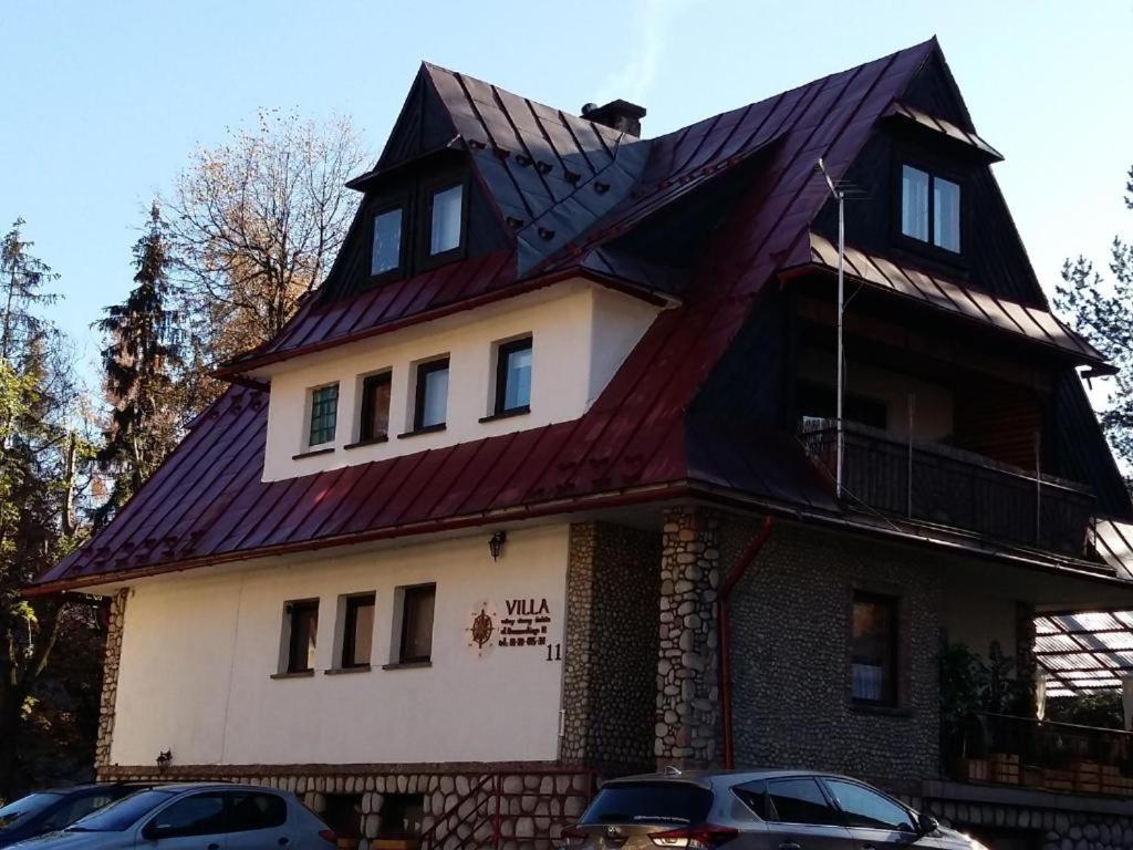 a house with a gambrel roof on top of it at Villa Cztery Strony Świata in Zakopane