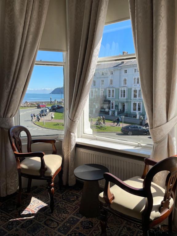 a room with two chairs and a large window at Montclare in Llandudno