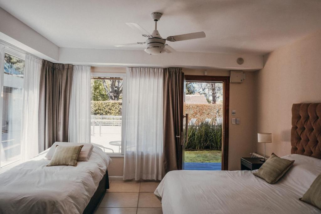 een slaapkamer met 2 bedden en een groot raam bij Aqualina Suites in Valeria del Mar