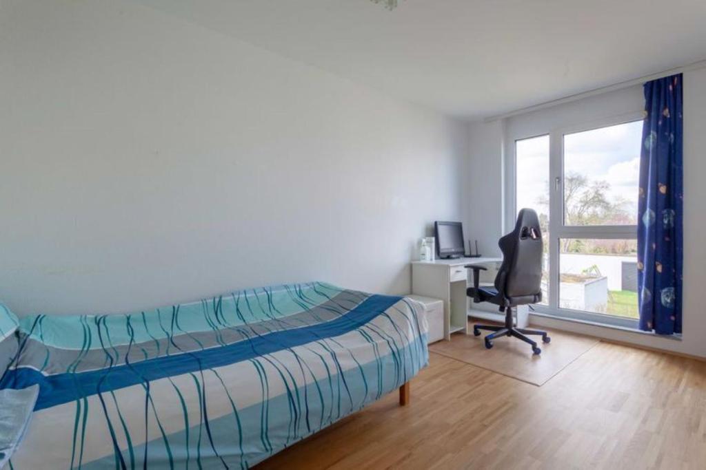 Schlafzimmer mit einem Bett, einem Schreibtisch und einem Stuhl in der Unterkunft Privat Zimmer Richtung Messe in Hannover