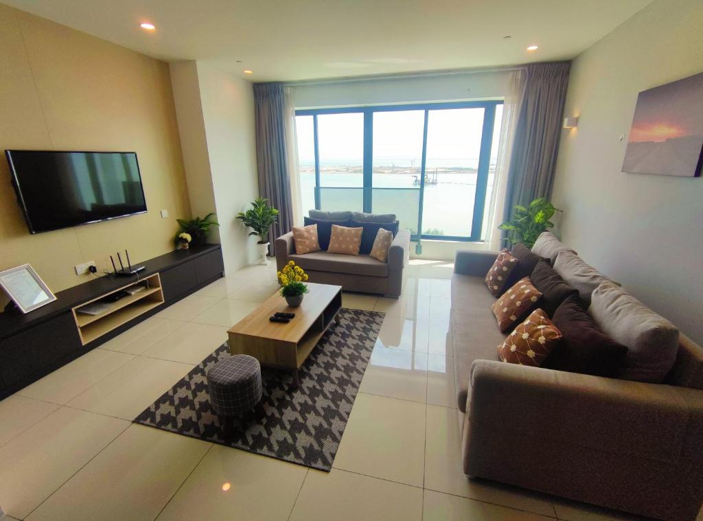 sala de estar amplia con sofás y TV en Seaview Duplex Sunrise Gurney 2BR 一级棒海景の楼中楼, en George Town