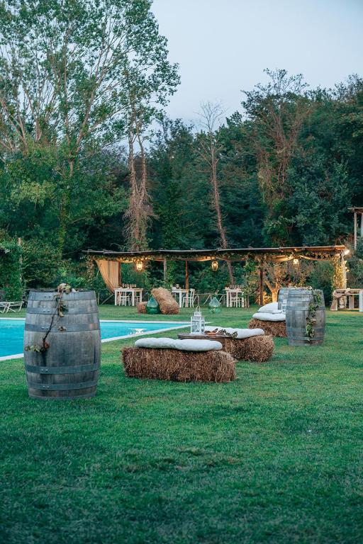 grupa beczek siedzących w trawie obok basenu w obiekcie La Pampa Relais & Spa w mieście Melizzano