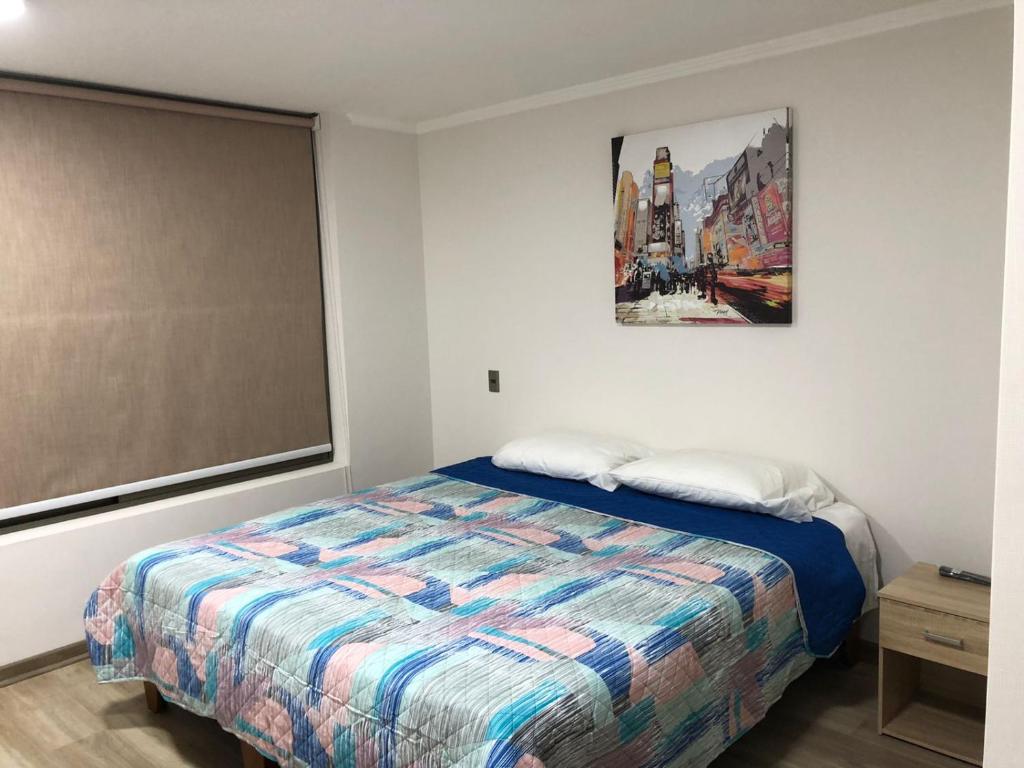 1 dormitorio con 1 cama y una pintura en la pared en ALTOS DE HUAYQUIQUE, en Iquique