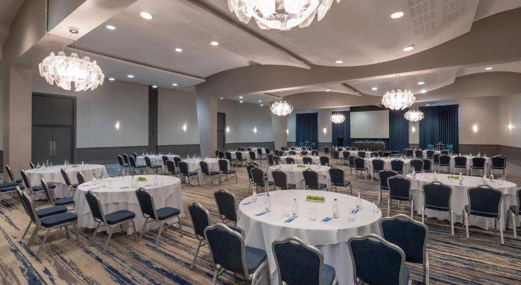 a banquet hall with white tables and chairs and chandeliers at Pillo Hotel & Leisure Club in Ashbourne