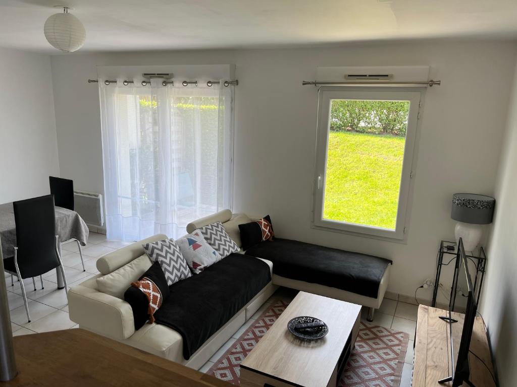 a living room with a couch and a window at Appartement + Jardin in Fouesnant