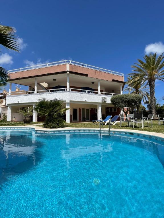 a large swimming pool in front of a house at Anna's garden in Torrevieja