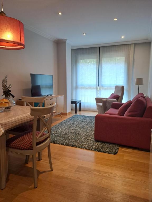 a living room with a red couch and a tv at Apartamento en el centro con garaje directo. in Bilbao