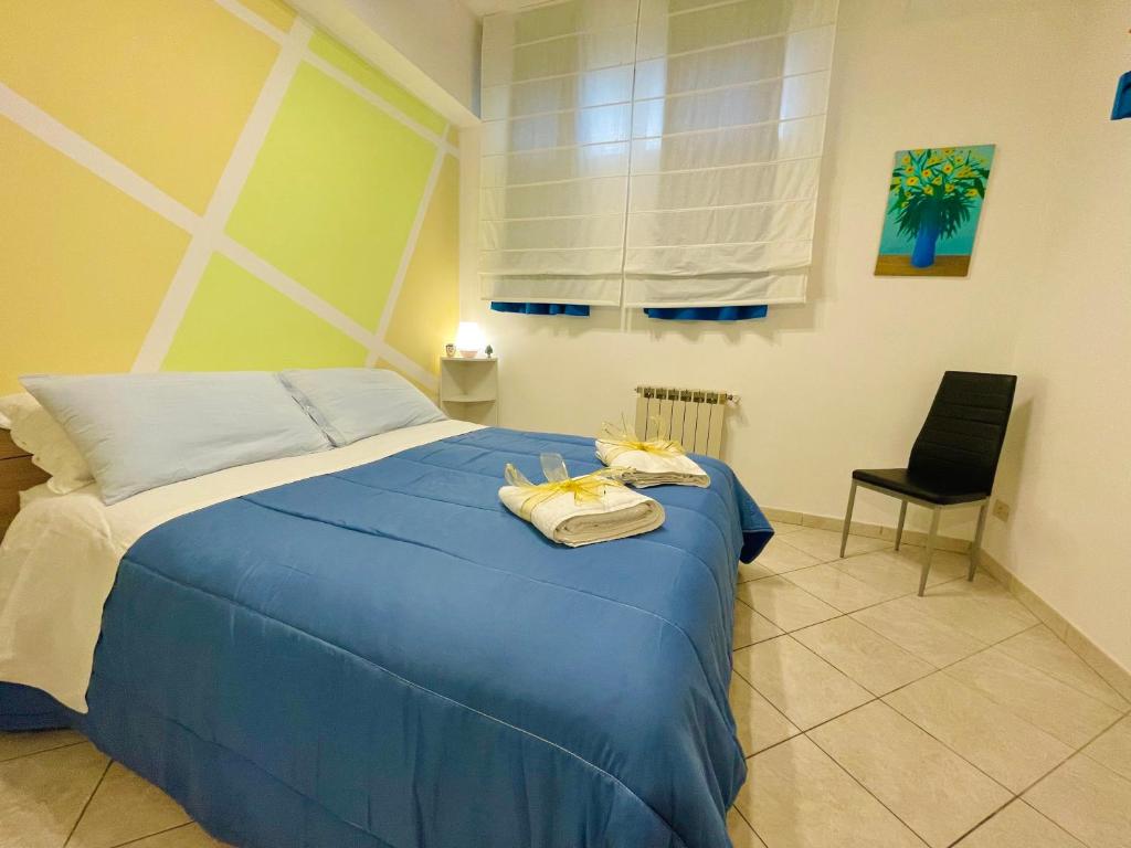 una camera da letto con un letto blu con sopra degli asciugamani di Casa Mare Naxos Flat - Home Holiday a Giardini Naxos