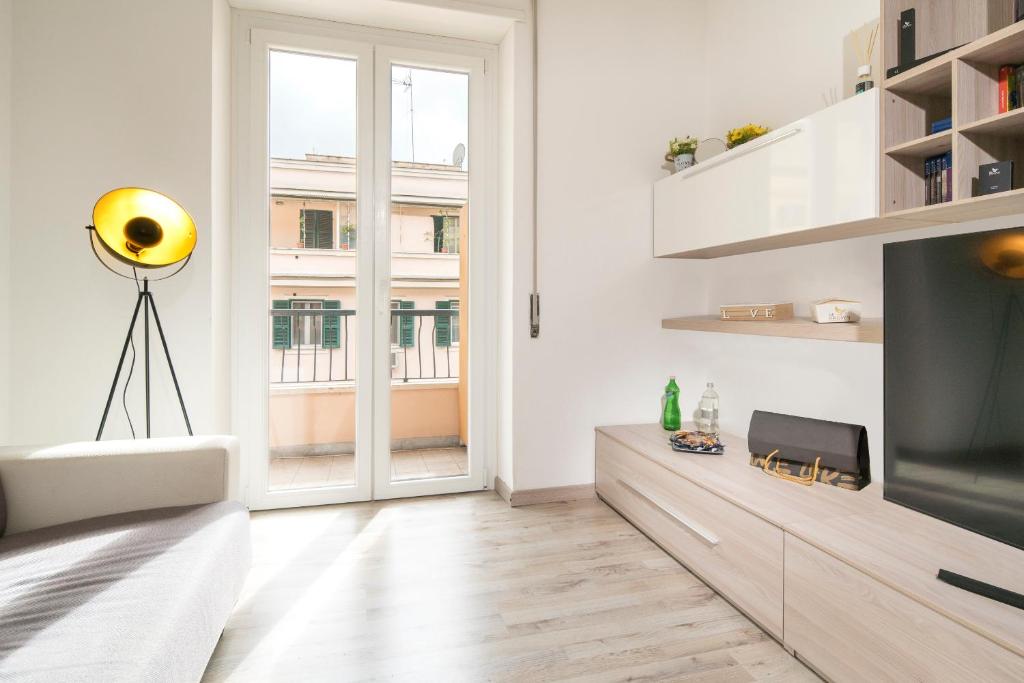 Biały salon z telewizorem i dużym oknem w obiekcie Mr. Brown - Camillo w Rzymie
