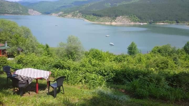 uma mesa e cadeiras com vista para um lago em Vikendica Vidikovac na Zavojskom jezeru em Pirot