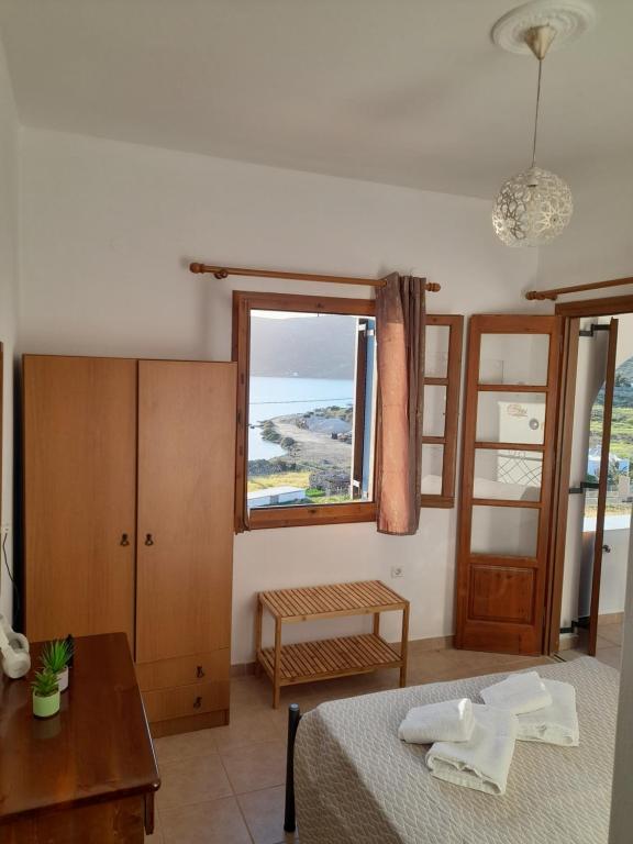 a bedroom with a bed and a table and a window at Aggeliki's Apartments in Lipsoi