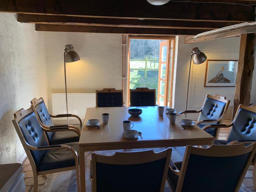 uma sala de jantar com uma mesa e cadeiras e uma janela em Navröds Gård em Sjöbo