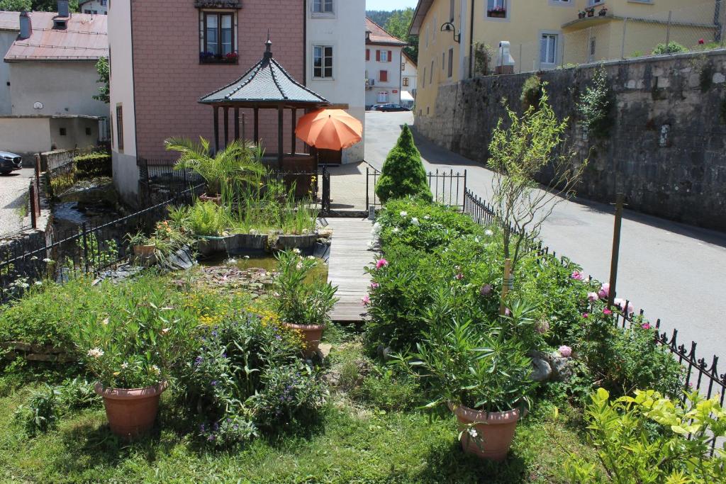 einen Garten mit einem Pavillon und einigen Pflanzen in der Unterkunft Chez Ginette et Jean-François in Le Chenit