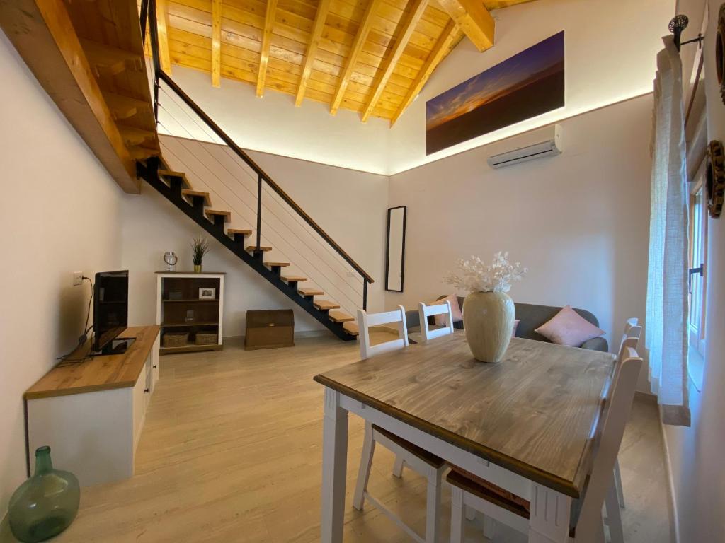 a living room with a table and a staircase at Casa De Los Silos 