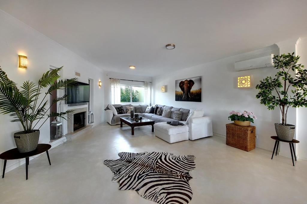 a living room with a zebra rug on the floor at Casinha do Sol in Almancil
