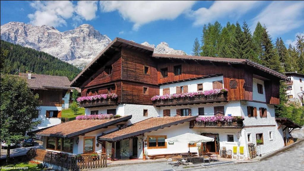 a large building with flowers on the balconies of it at HOTEL BOSCO VERDE in Val di Zoldo