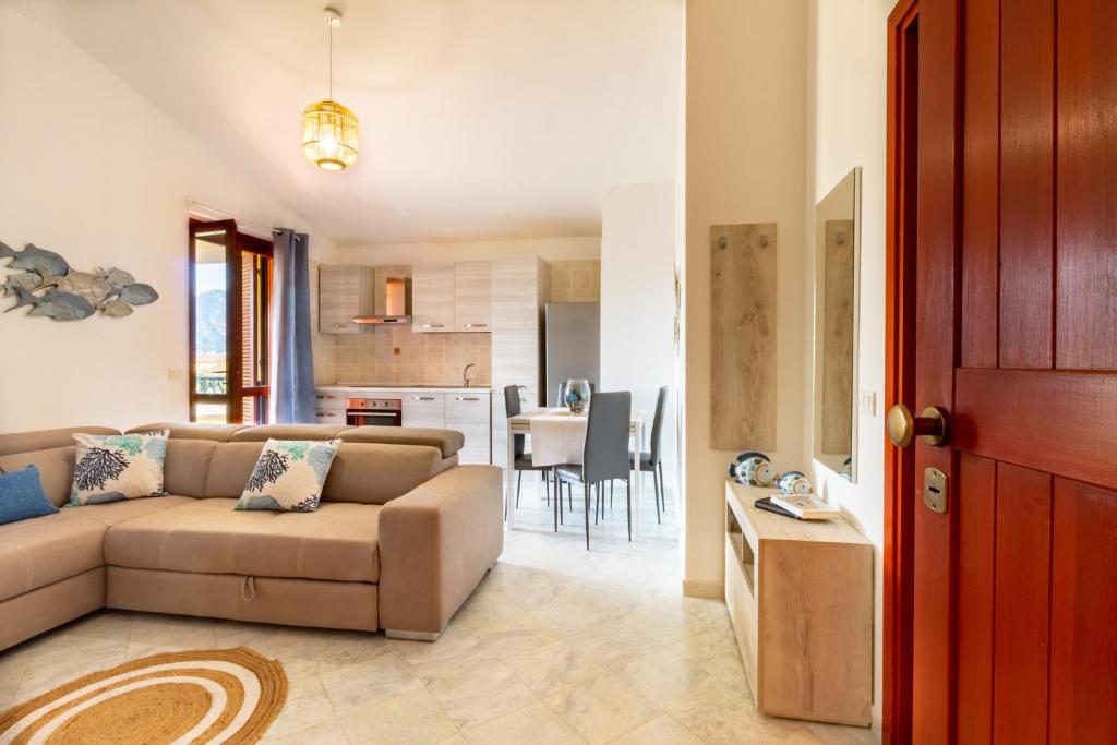 ein Wohnzimmer mit einem Sofa und einer Küche in der Unterkunft Trivano Villasimius in Villasimius
