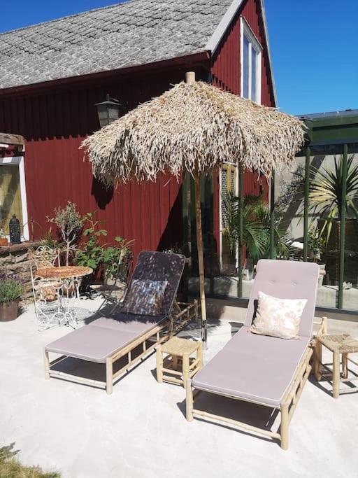 two chairs and an umbrella and a table and a table at Mojo organic spa in Borgholm