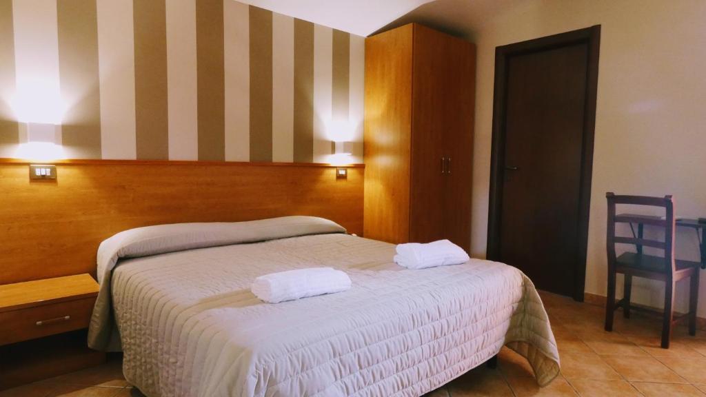 1 dormitorio con 1 cama con 2 toallas en Hotel Piscina La Suite, en Prossedi