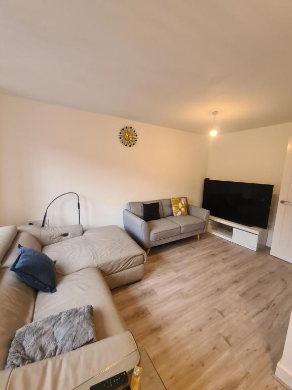 ein Wohnzimmer mit 2 Sofas und einem Flachbild-TV in der Unterkunft lovely new home in manchester close to MANCHESTER CITY FC in Manchester