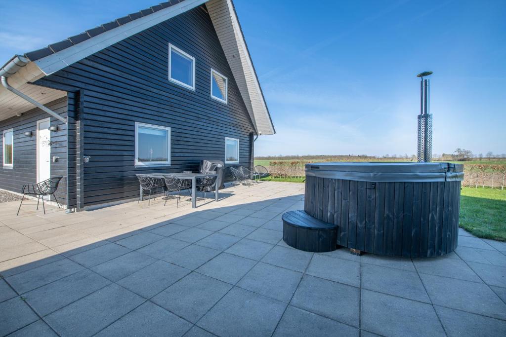 eine Terrasse mit einem Tisch und einem Gebäude in der Unterkunft Fuglhus - hyggelig ferie på landet in Rødekro