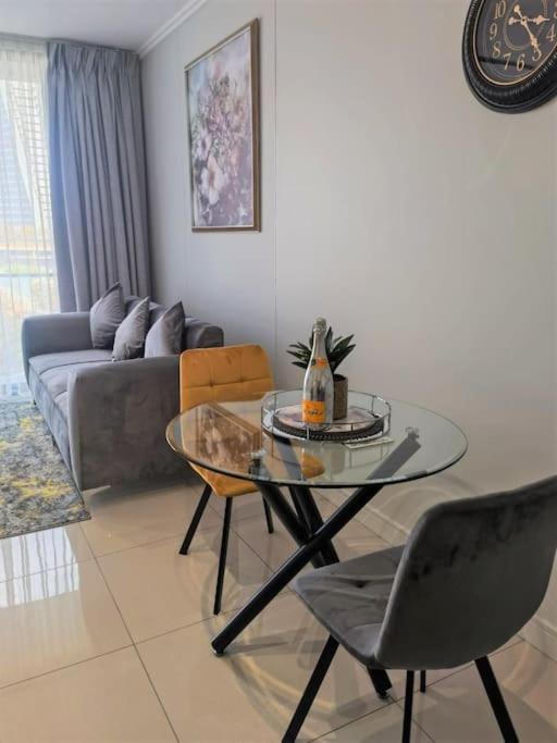 a living room with a glass table and a couch at Executive Suite at Ellipse in Waterfall Midrand in Midrand