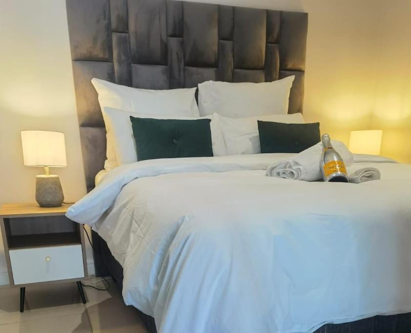 a bedroom with a large white bed with a large headboard at Executive Suite at Ellipse in Waterfall Midrand in Midrand