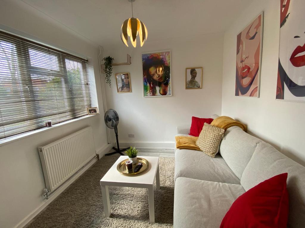 a living room with a couch and a table at Stylish 4 Bedroom House with Private Parking and Free WiFi in Milton Keynes by HP Accommodation in Milton Keynes