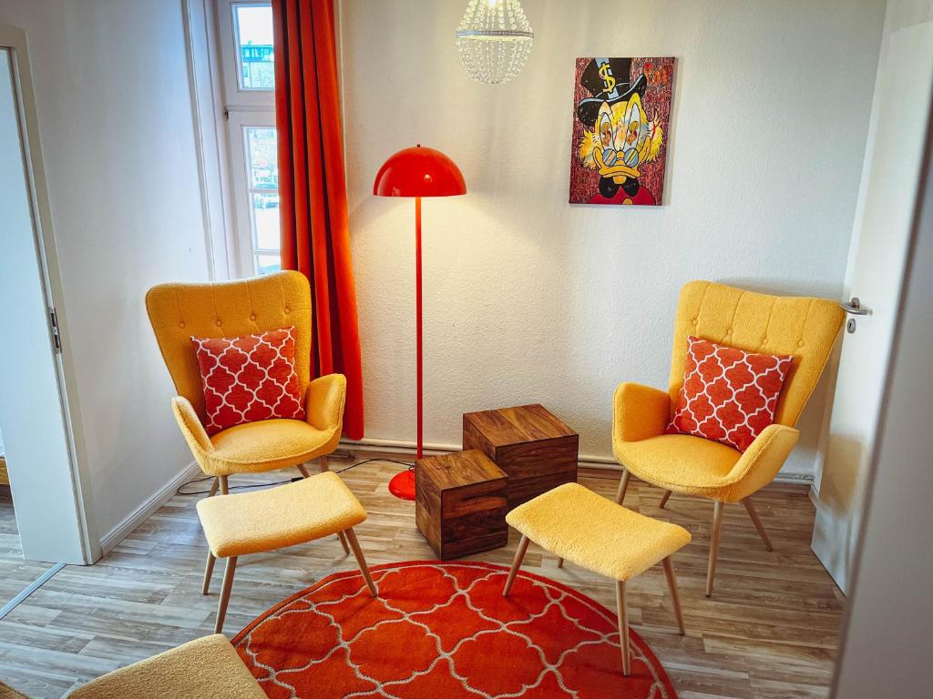 un soggiorno con 2 sedie e una lampada rossa a pavimento di 1a Citylage-Haus im Centrum! ad Amburgo