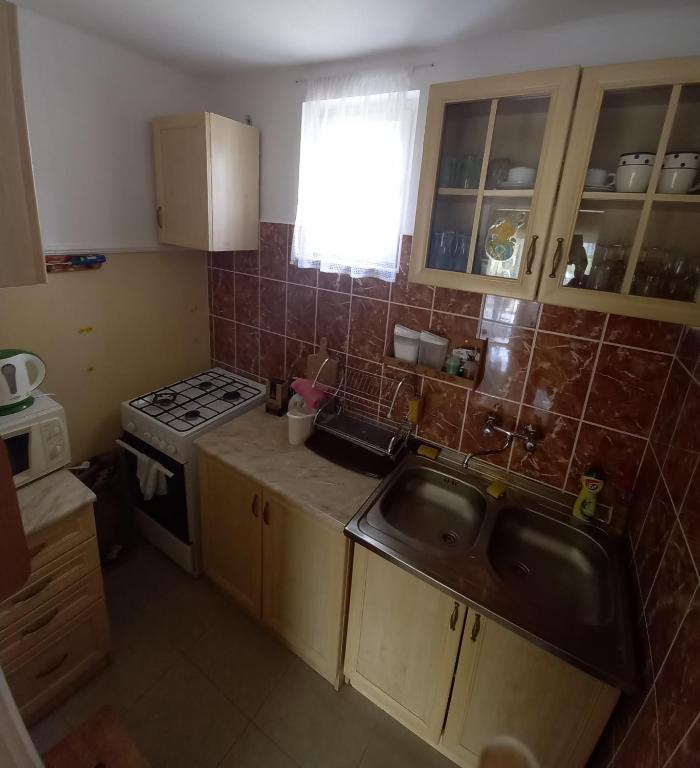 małą kuchnię ze zlewem i kuchenką w obiekcie Barázda Apartman w mieście Berekfürdő