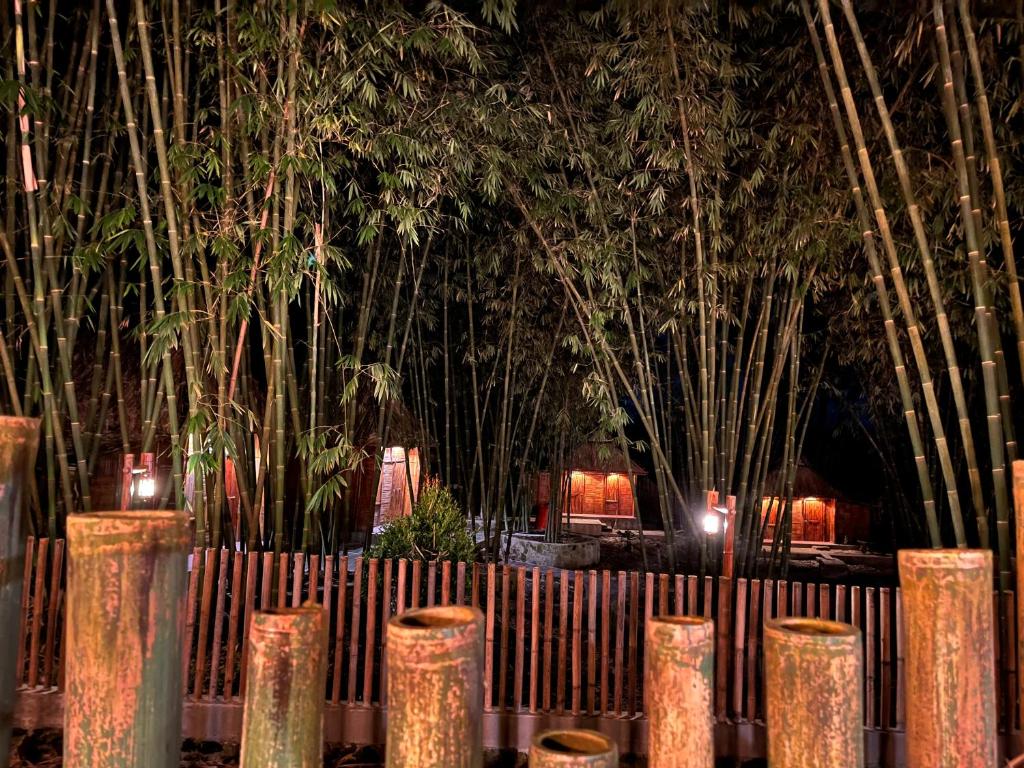 a wooden fence with bamboo trees in the background at Para para cafe & cottage in Berastagi