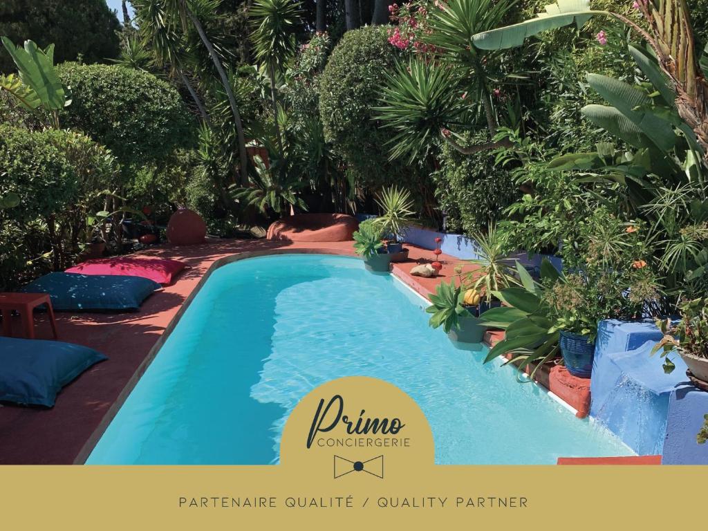 a swimming pool in a resort with a sign that reads prime supermarket at "La Villa Bali", en Bord de Mer à 5 mn des plages avec Piscine à cascade, Grand extérieur unique sur le thème de Bali in Six-Fours-les-Plages