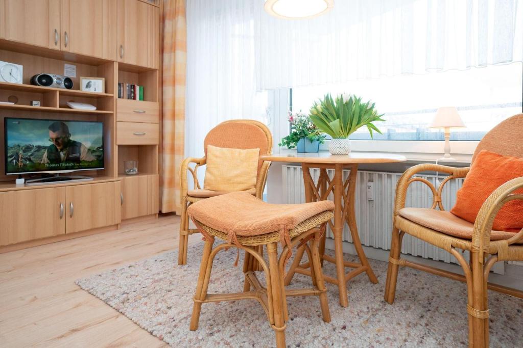 ein Wohnzimmer mit einem Tisch und Stühlen sowie einem TV in der Unterkunft Haus Ankerlicht 1.OG Wohnung 66 in Westerland