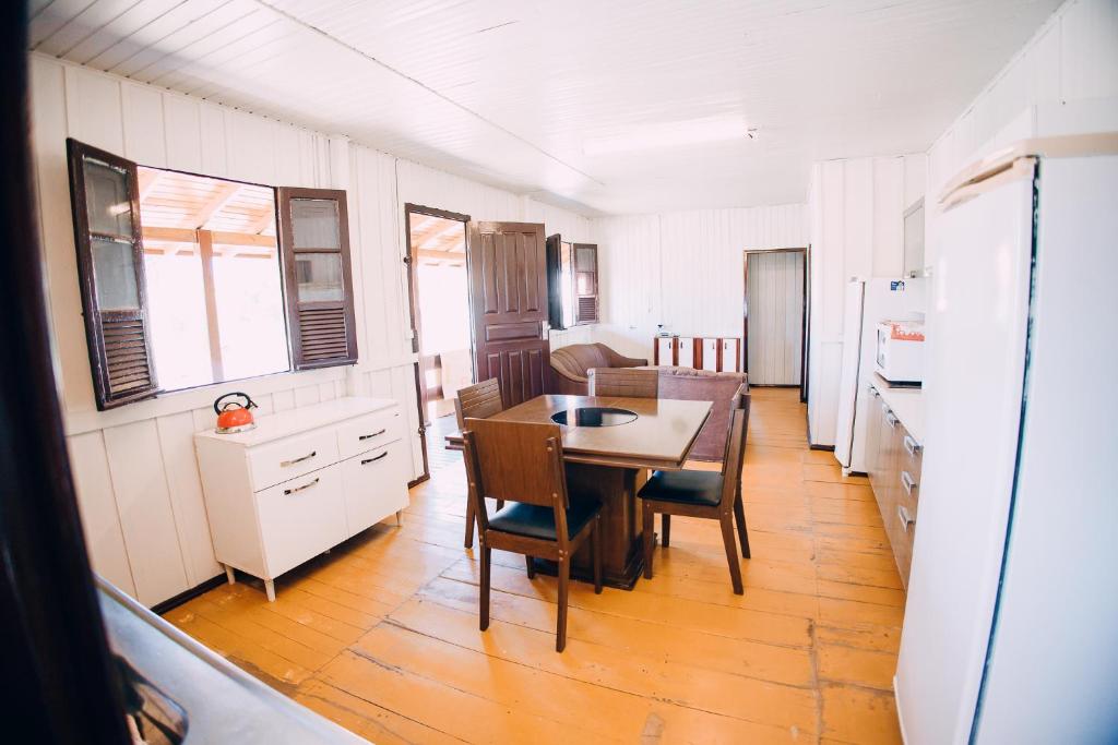 a kitchen and dining room with a table and chairs at Recanto Figueirinha in Jaguaruna