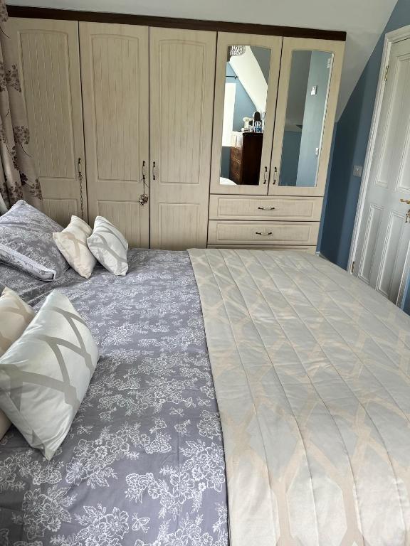a large bed with two pillows on top of it at Stone Lodge B&B in Balrath