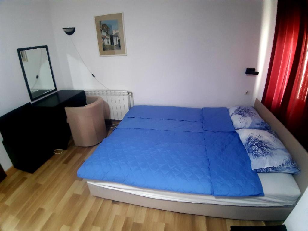 a bedroom with a bed with blue sheets and a mirror at VN APARTMENTS OHRID in Ohrid